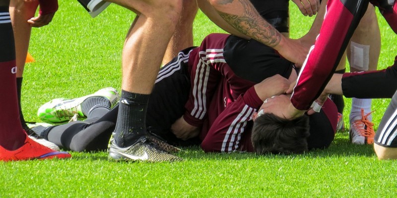 Football player on ground suffering from a sports injury
