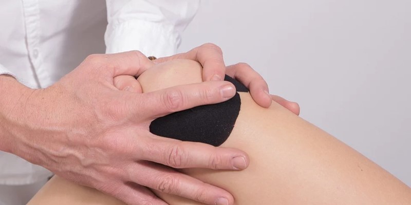 Chiroprator helping client with knee pain
